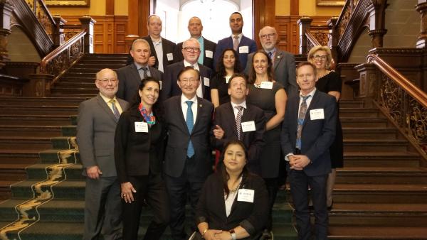 Minister Cho with invited guests on and in front of stairs in the Ontario Legislative Building